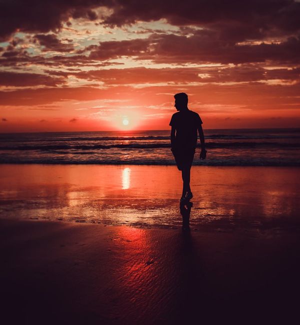 Silhouette of a person meditating against a warm sunset.